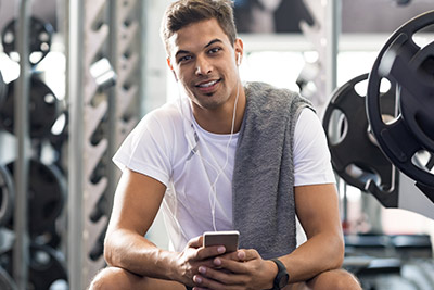 Man in a gym on his phone using an app