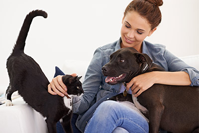 woman petting a cat and a dog