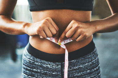 woman measuring her waistline